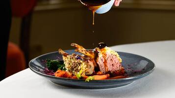 A dish with meat, vegetables, and sauce on a plate.