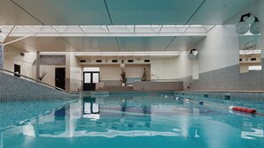 An indoor swimming pool with clear water, a tiled floor, and a lifeguard chair. - County Arms Birr (Birr)