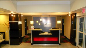A reception desk with a Holiday Inn Express sign, a fire extinguisher, and a red illuminated panel. - Holiday Inn Express and Suites Corpus Christi North by IHG (Corpus Christi)