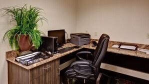A reception desk with a computer, printer, and a potted plant. - Holiday Inn Express & Suites Wichita Northwest by IHG (Maize)