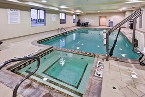 Una piscina con tabla de clavados, normas de la piscina y silla de socorrista.