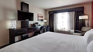 A hotel room with a large bed, a desk with a flat-screen TV, a coffee maker, and a window with curtains. - Holiday Inn Express & Suites Wichita Northwest by IHG (Maize)