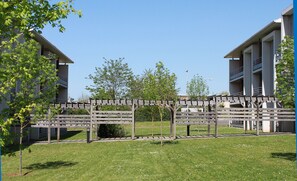 A modern building with a covered walkway and a grassy area.