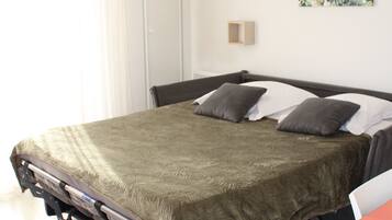 Una habitación de hotel moderna con una cama, una mesita de noche, una lámpara y una obra de arte colgada en la pared.