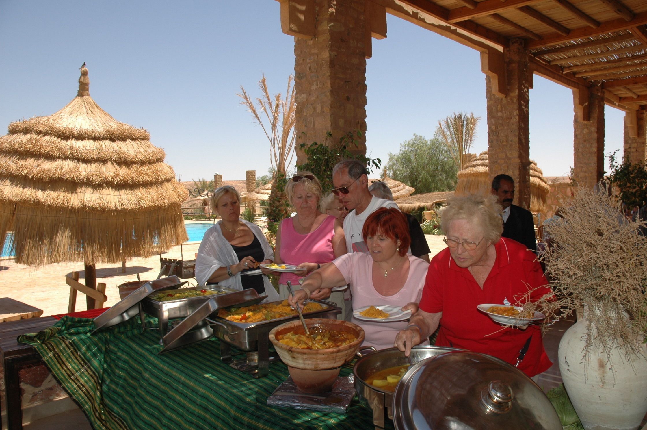 Een buffetopstelling met diverse gerechten en een grote pan stoofschotel.