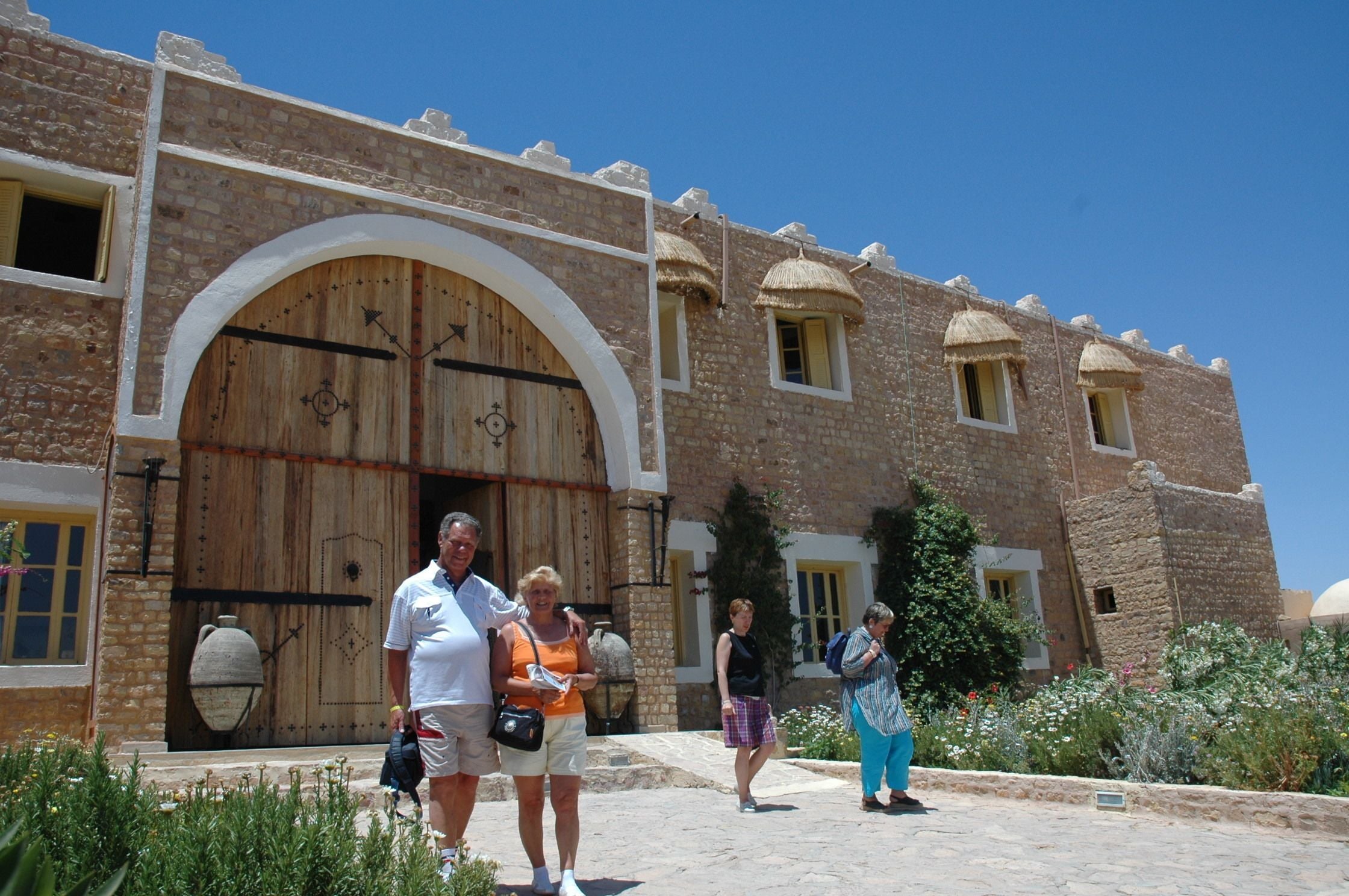 Un edifici històric amb una porta de fusta gran i finestres d'arc.