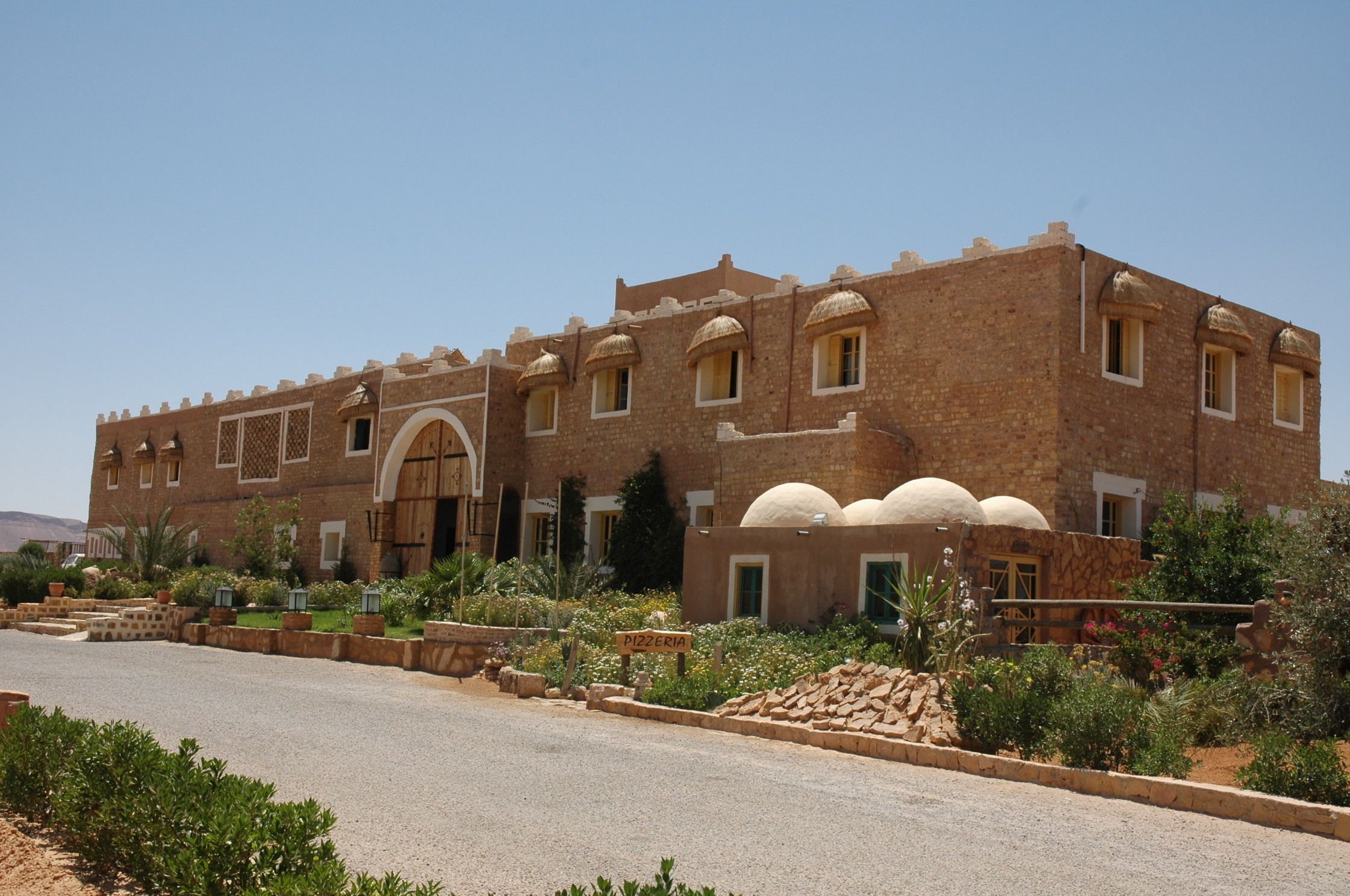 A large brick building with multiple windows and a central archway.