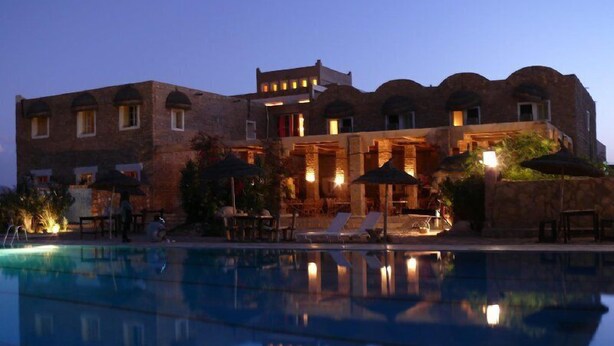 A large building with a swimming pool in front.
