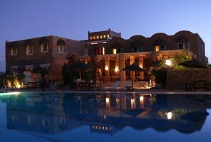 Un edificio grande con una piscina al frente.