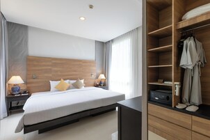 Una habitación de hotel moderna con una cama grande, lámparas de noche, un armario empotrado y un panel de control.