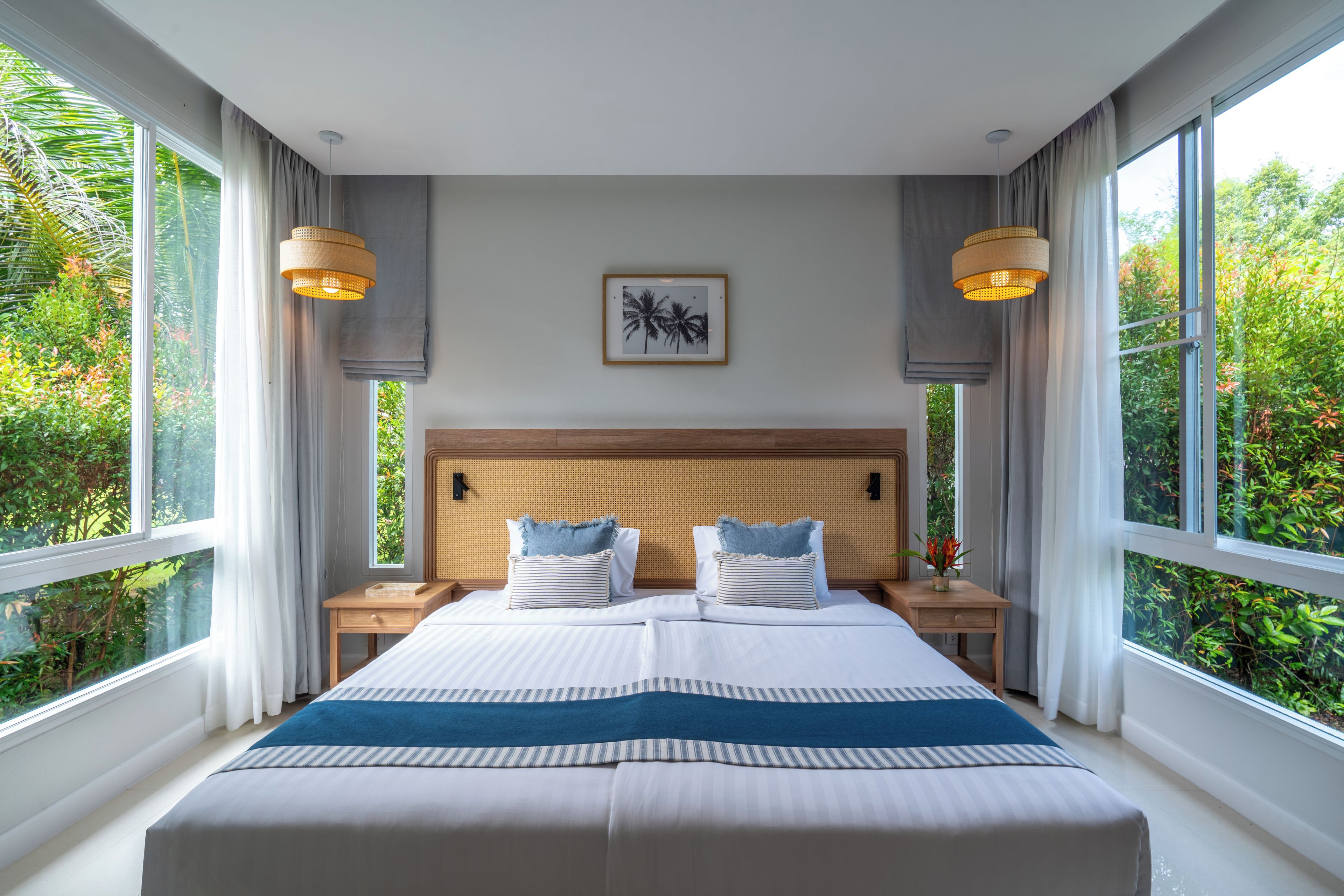 A large bed with a wooden headboard, two bedside tables, and a framed picture on the wall.