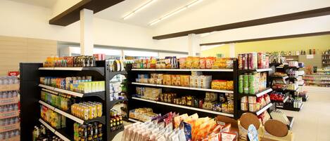 A grocery store interior with shelves stocked with various food items and beverages.