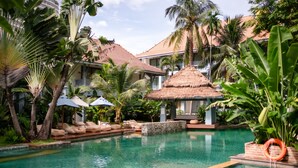 A pool area with lounge chairs, a thatched-roof structure, and palm trees. - The Peri Hotel Hua Hin (Hua Hin)
