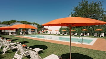Una piscina cubierta, una piscina al aire libre de temporada, sombrillas