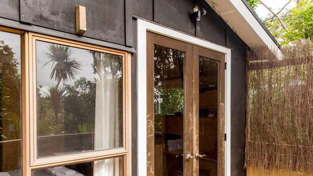 Une façade en bois avec une porte-fenêtre coulissante et une fenêtre.
