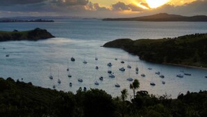 Un paysage côtier avec des bateaux ancrés dans des eaux calmes, entouré de collines et sous un ciel dégagé.