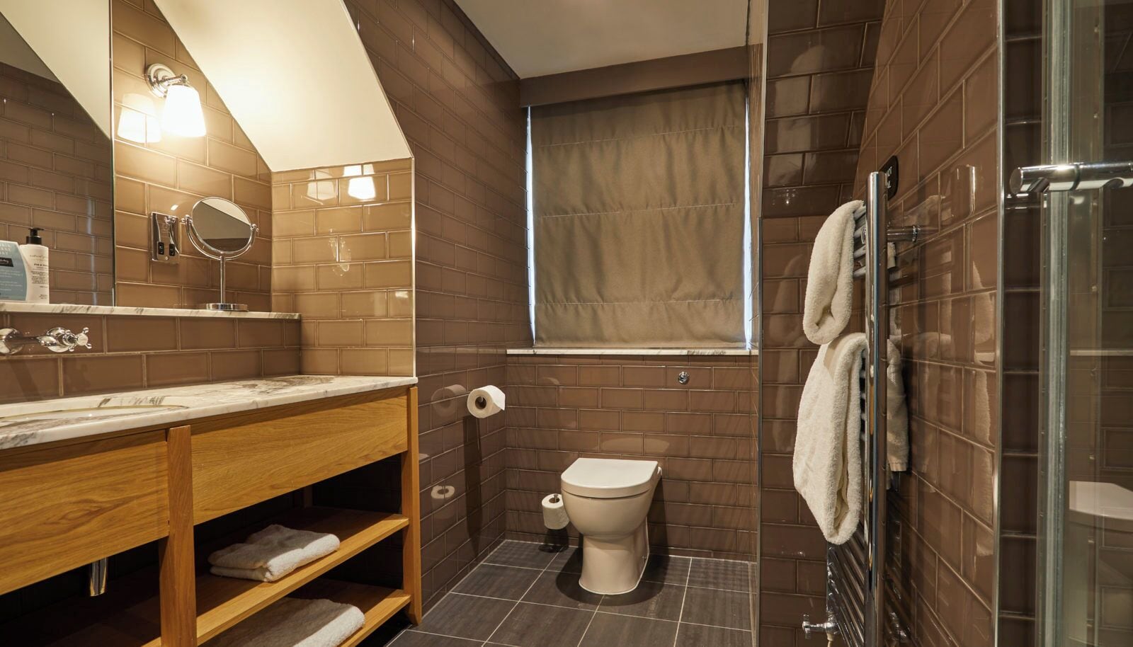 Une salle de bain moderne avec un meuble-lavabo en bois, des toilettes, une douche et un grand miroir.
