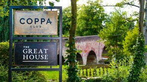 A sign for 'COPPA CLUB' and 'THE GREAT HOUSE' with a stone bridge in the background. - The Great House, Sonning, Berkshire (Reading)