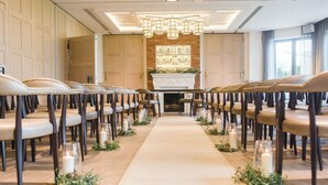 A long aisle with rows of chairs on either side, leading to a central area with a fireplace and a white mantelpiece. - The Great House, Sonning, Berkshire (Reading)