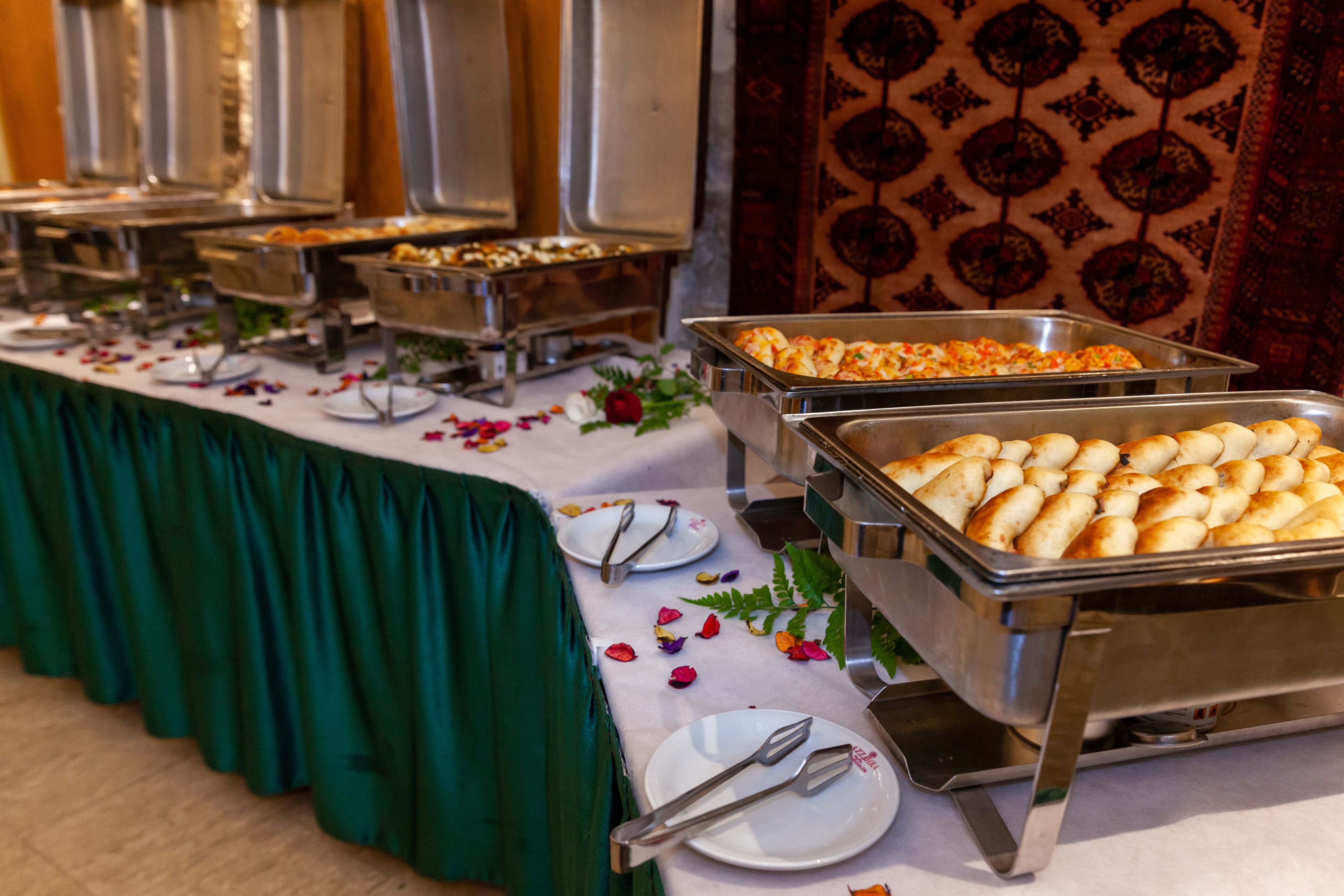 A buffet table with various food items and utensils.
