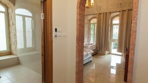 A hallway with a tiled floor, a wooden door frame, and a brick wall. - Azzahra Boutique Hotel & Restaurant - Jerusalem (Jerusalem)
