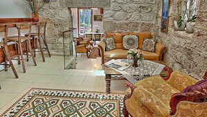 A cozy living room with a stone wall, a sofa, a coffee table, and a patterned rug.