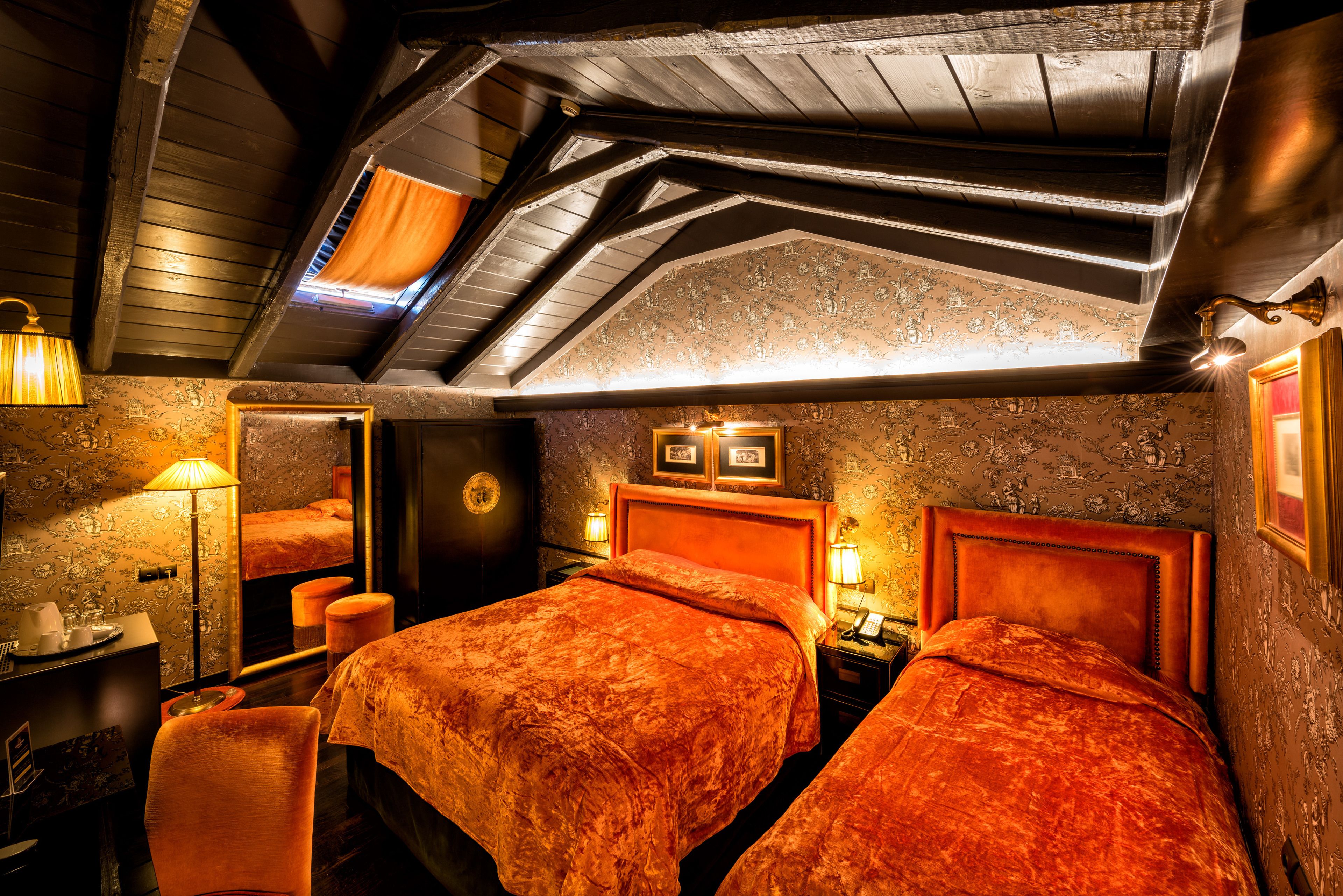 A room with two beds, a desk, a chair, and a small table.