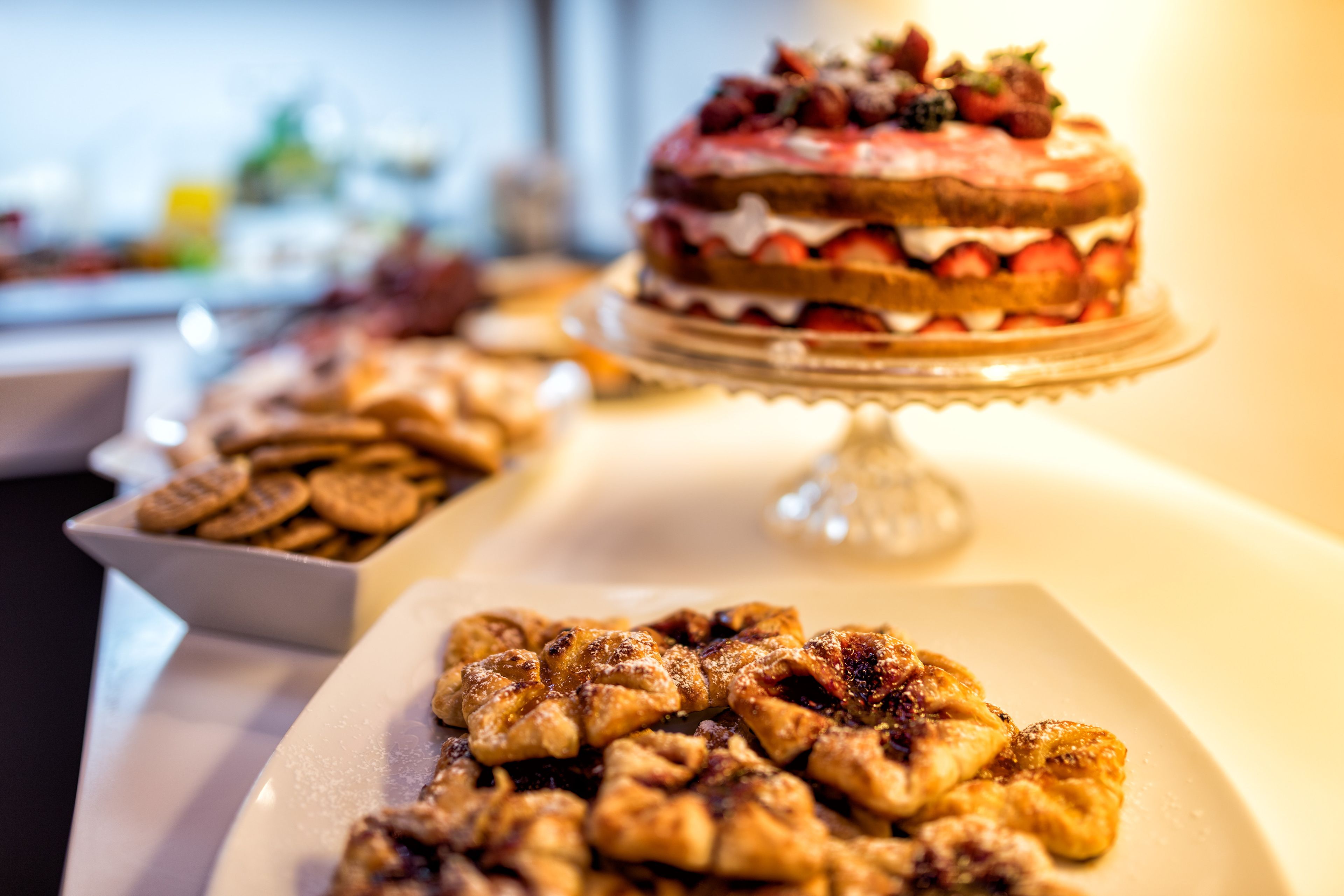 A dessert table with a variety of pastries and a decorated cake.