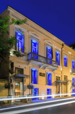 Un edificio histórico con balcones ornamentados e iluminación azul.