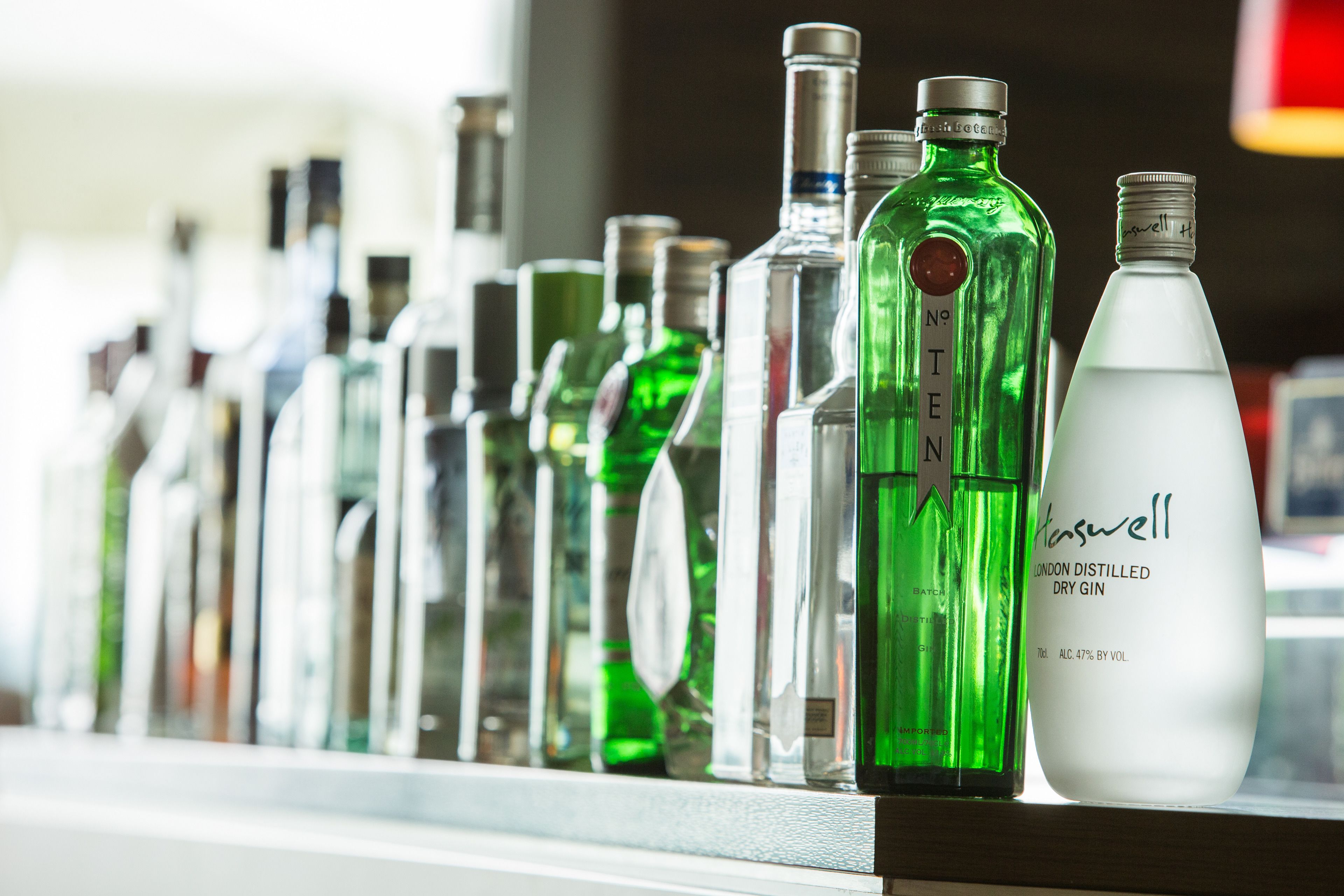 A variety of liquor bottles on a shelf.