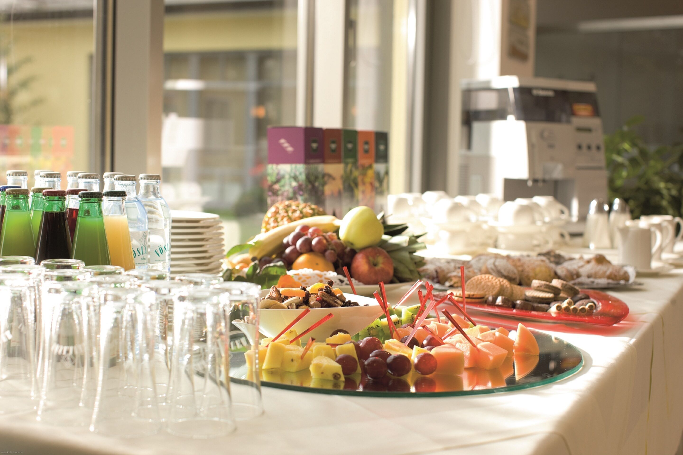 A buffet table with various food items and beverages.