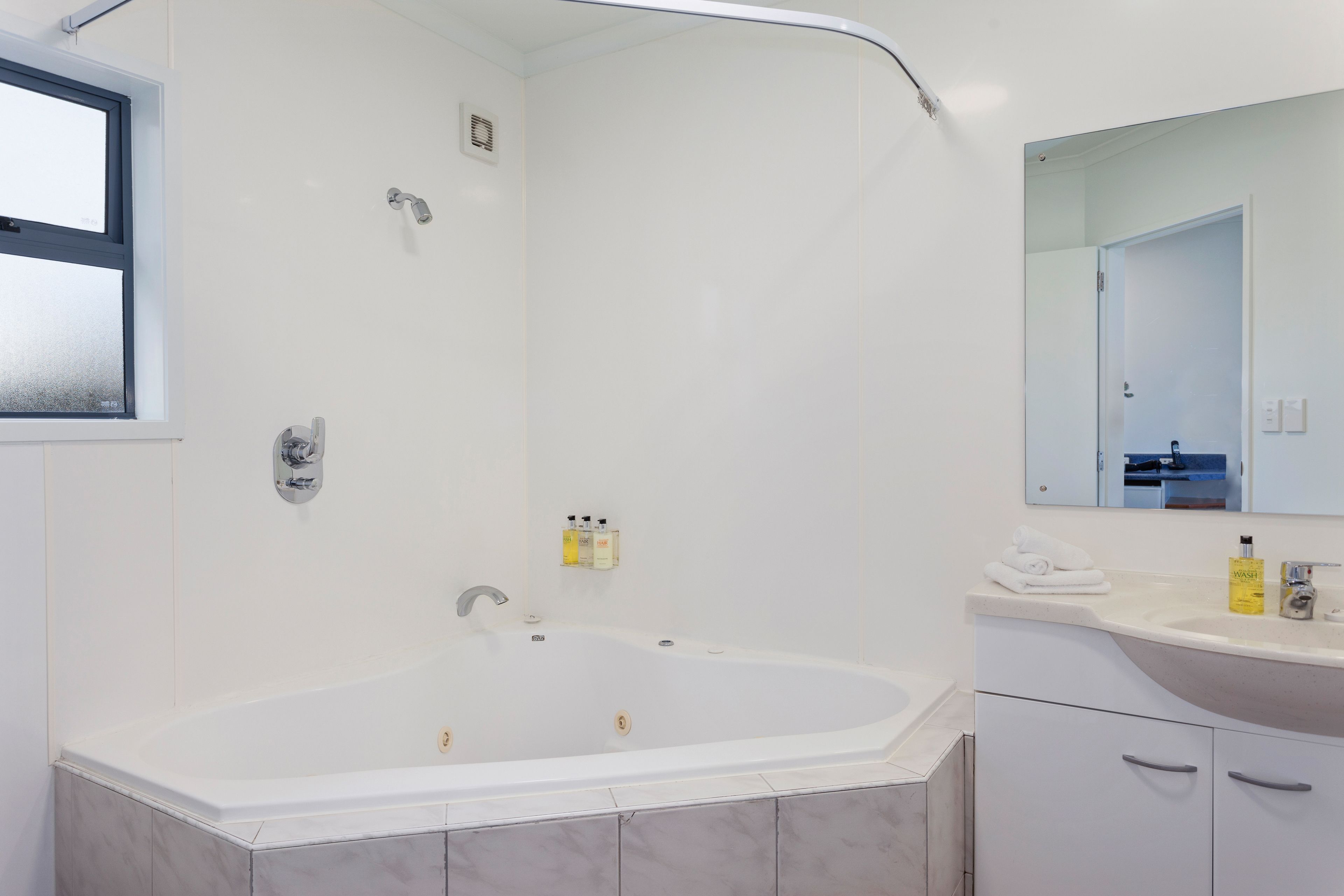Une salle de bain moderne avec une baignoire sur pieds, un meuble-lavabo avec miroir et un espace douche.