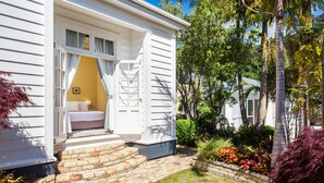 Une maison blanche avec un chemin de briques menant à la porte d’entrée.