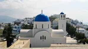 Un edificio blanco con cúpula azul y, al fondo, otro edificio blanco más pequeño también con cúpula azul.