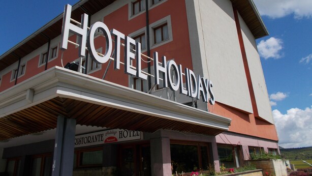 Um hotel com uma placa grande que diz "HOTEL HOLIDAYS".
