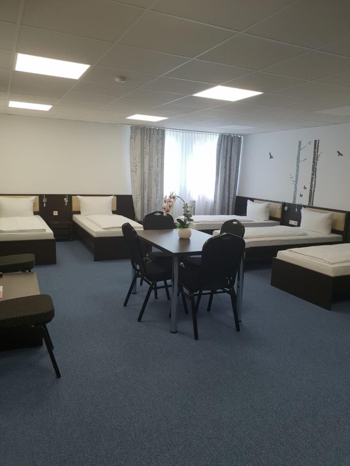 Une salle de conférence équipée d’une longue table, de quatre chaises et d’un coin salon avec deux canapés et un banc.