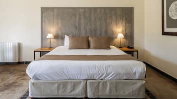 A large bed with two nightstands, each with a lamp, in a hotel room.