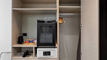 Una kitchenette compacta con cafetera, cápsulas de té y café, y microondas.
