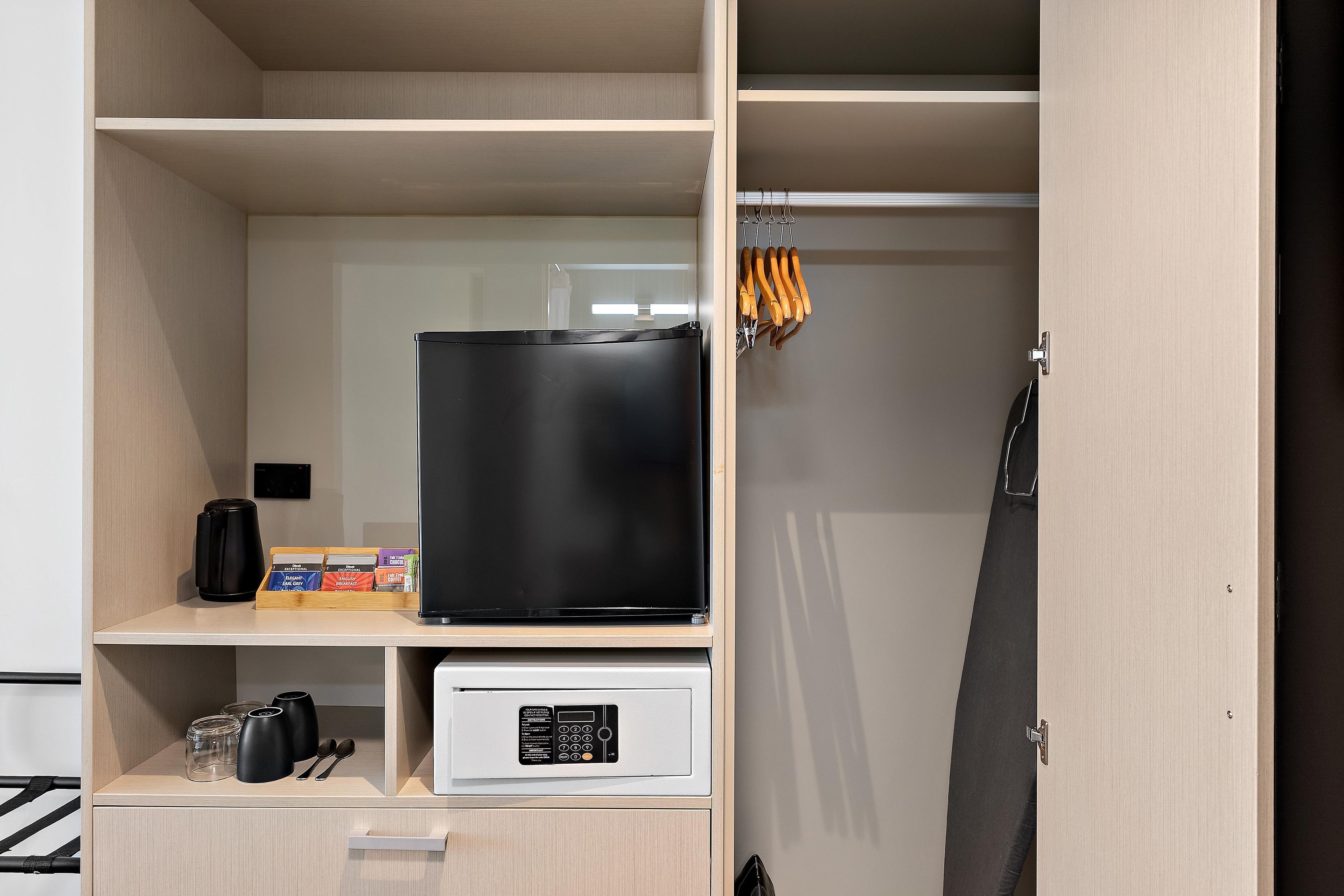 A hotel room with a minibar, a coffee machine, and a control panel for the minibar.