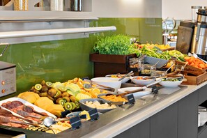 A buffet with various food items including fruits, vegetables, and meats.