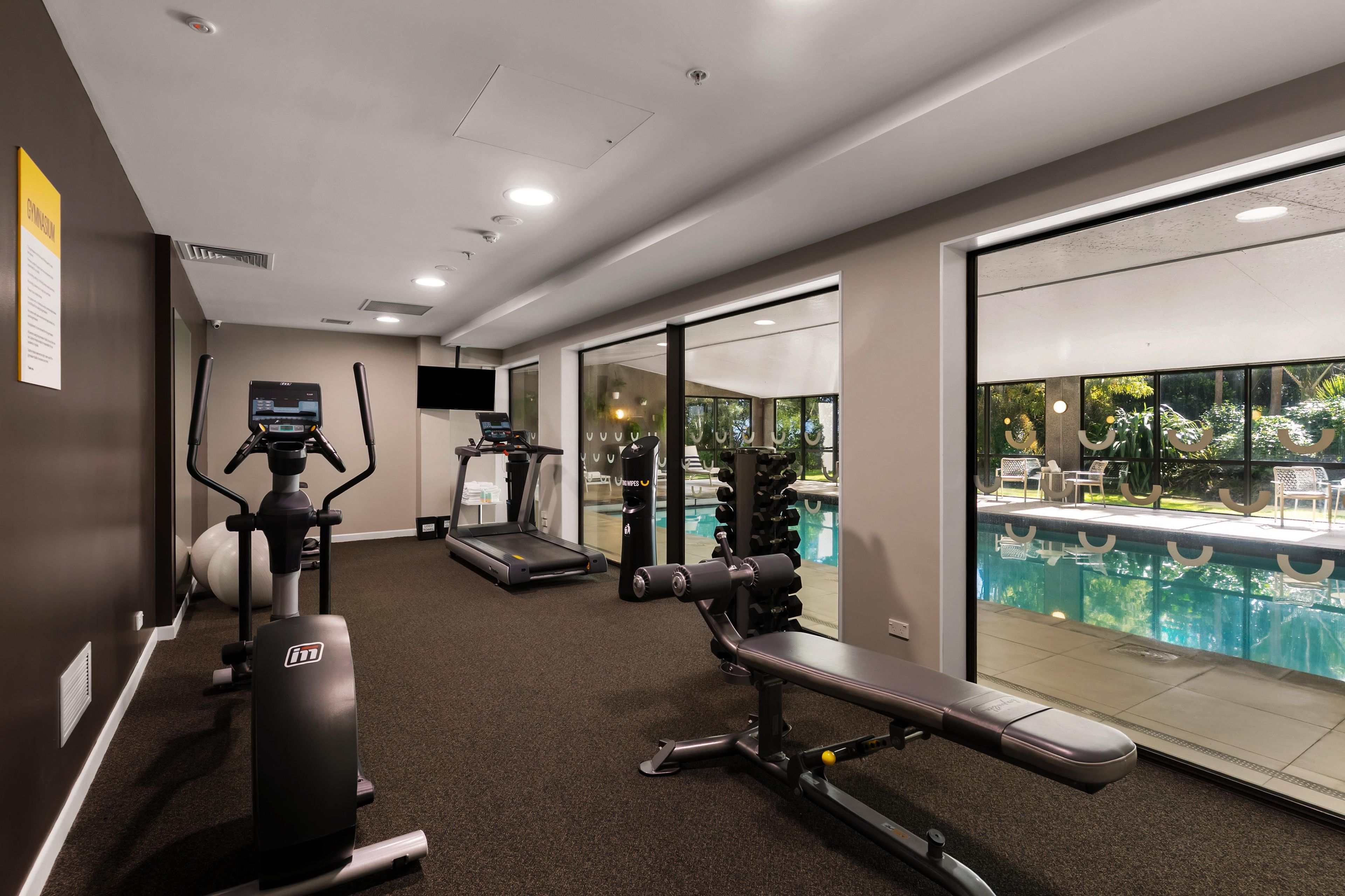 A gym with treadmills, a stationary bike, and a bench press.