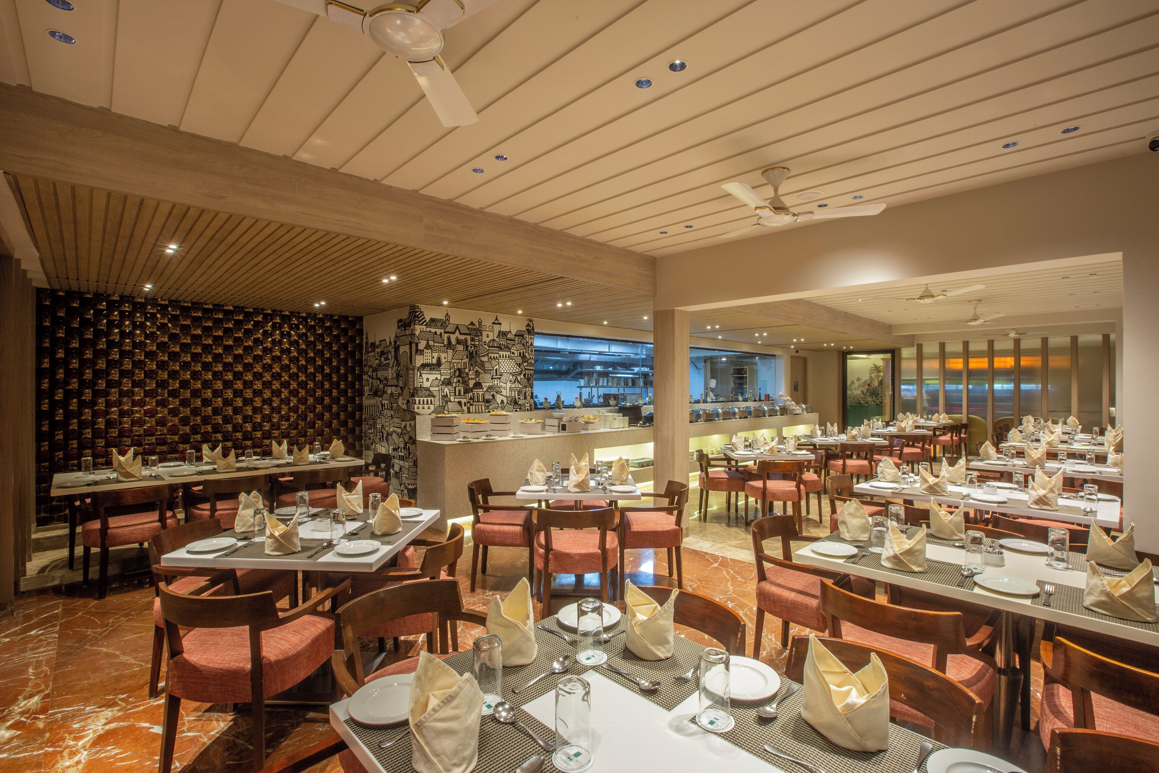 Un restaurant spacieux, doté de nombreuses tables pour accueillir les clients, avec un décor intérieur moderne et une vue imprenable sur la ville grâce à de grandes fenêtres.