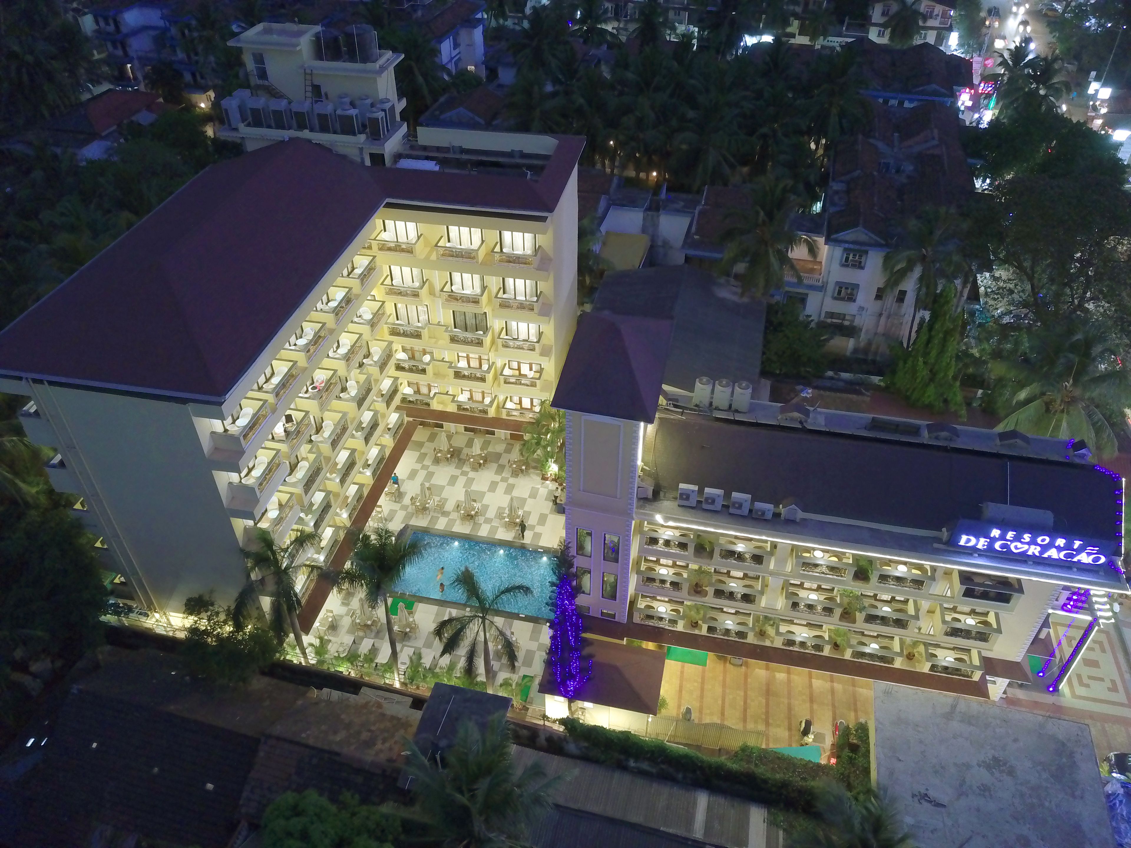 A hotel with multiple floors, a swimming pool, and a rooftop area.