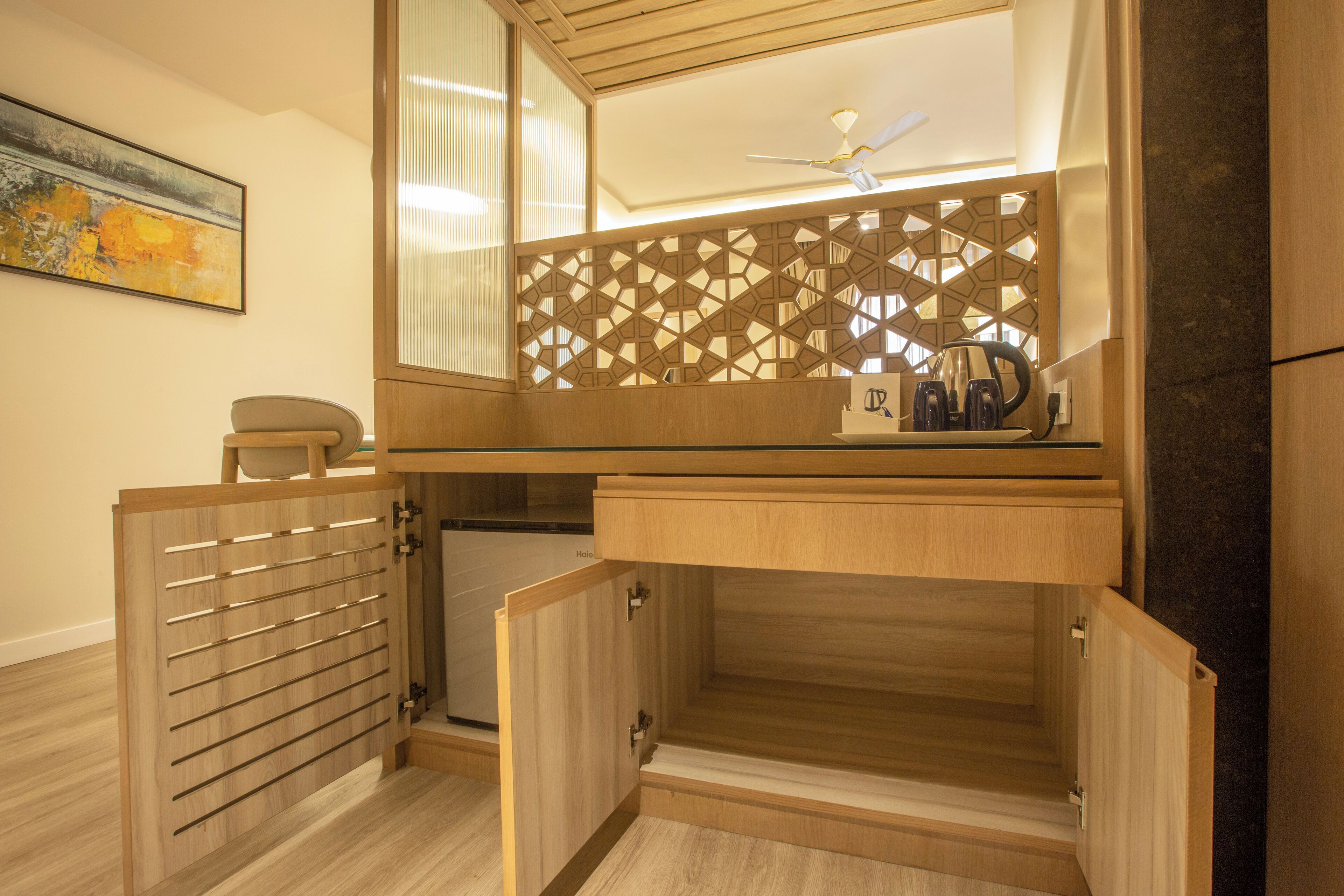 A modern bathroom with a wooden vanity, a towel rack, and a ceiling fan.