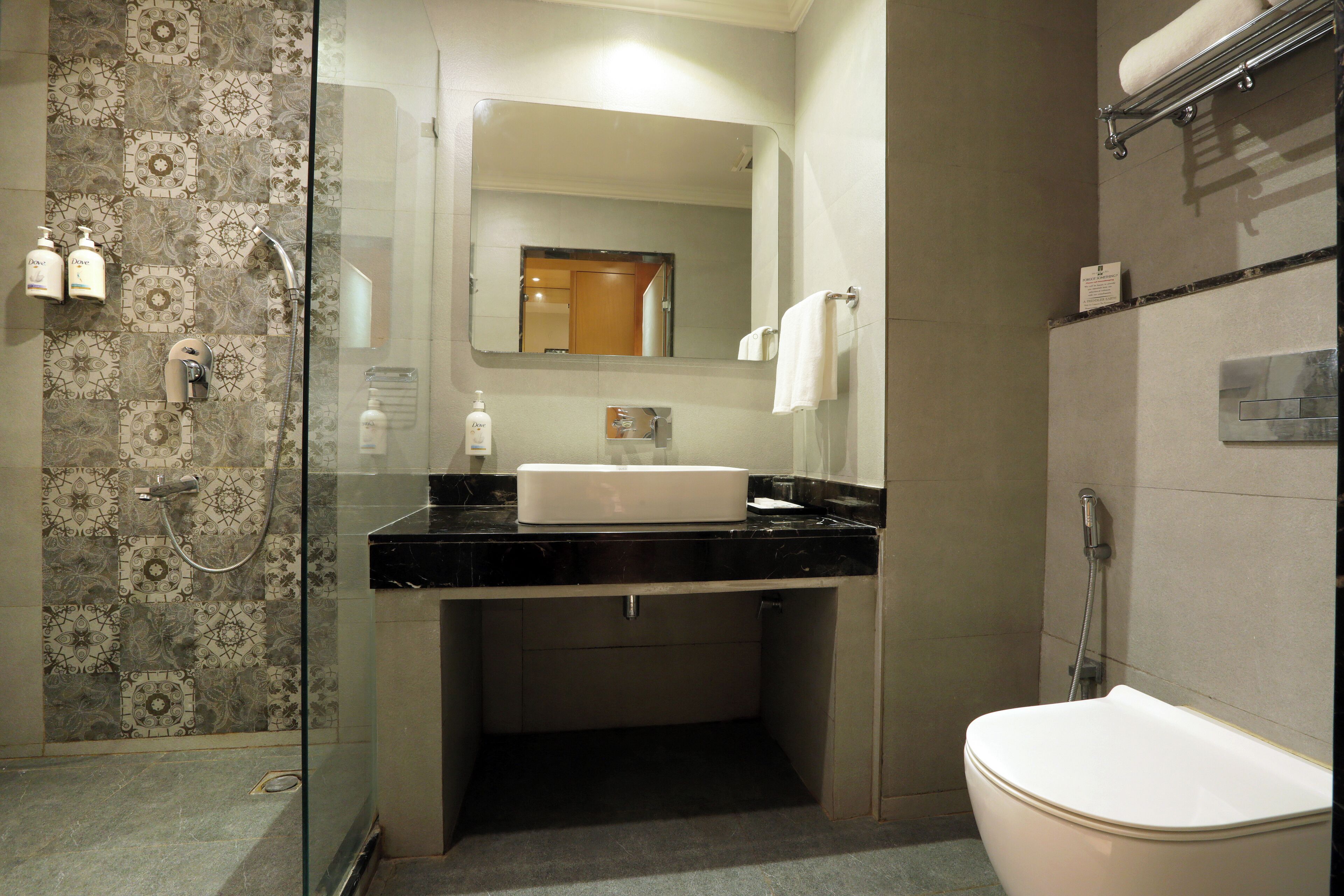 Un baño con cabina de ducha de vidrio, un lavabo blanco y un inodoro.