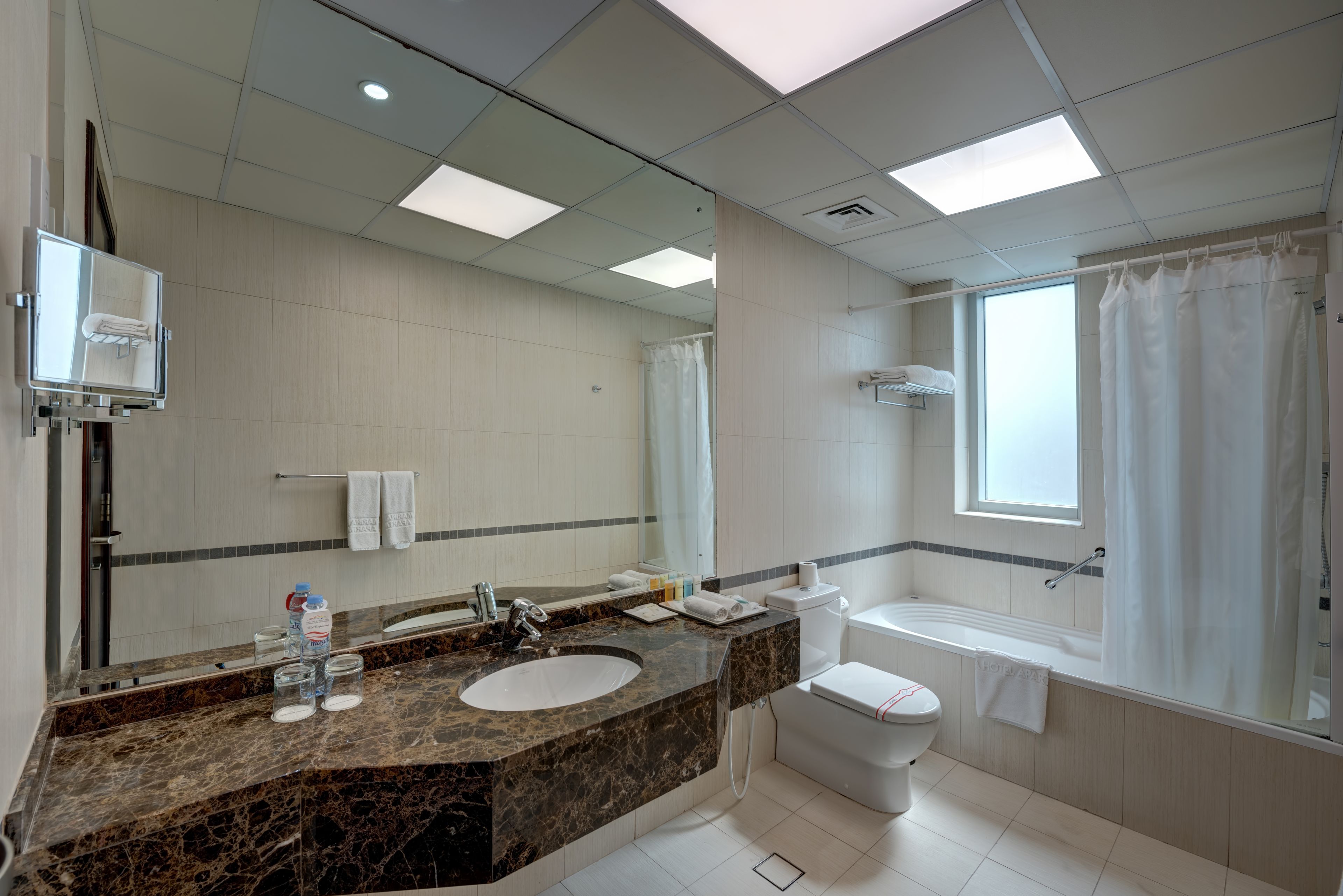Ein modernes Badezimmer mit einem мраморной Waschbecken, Toilette und Badewanne.