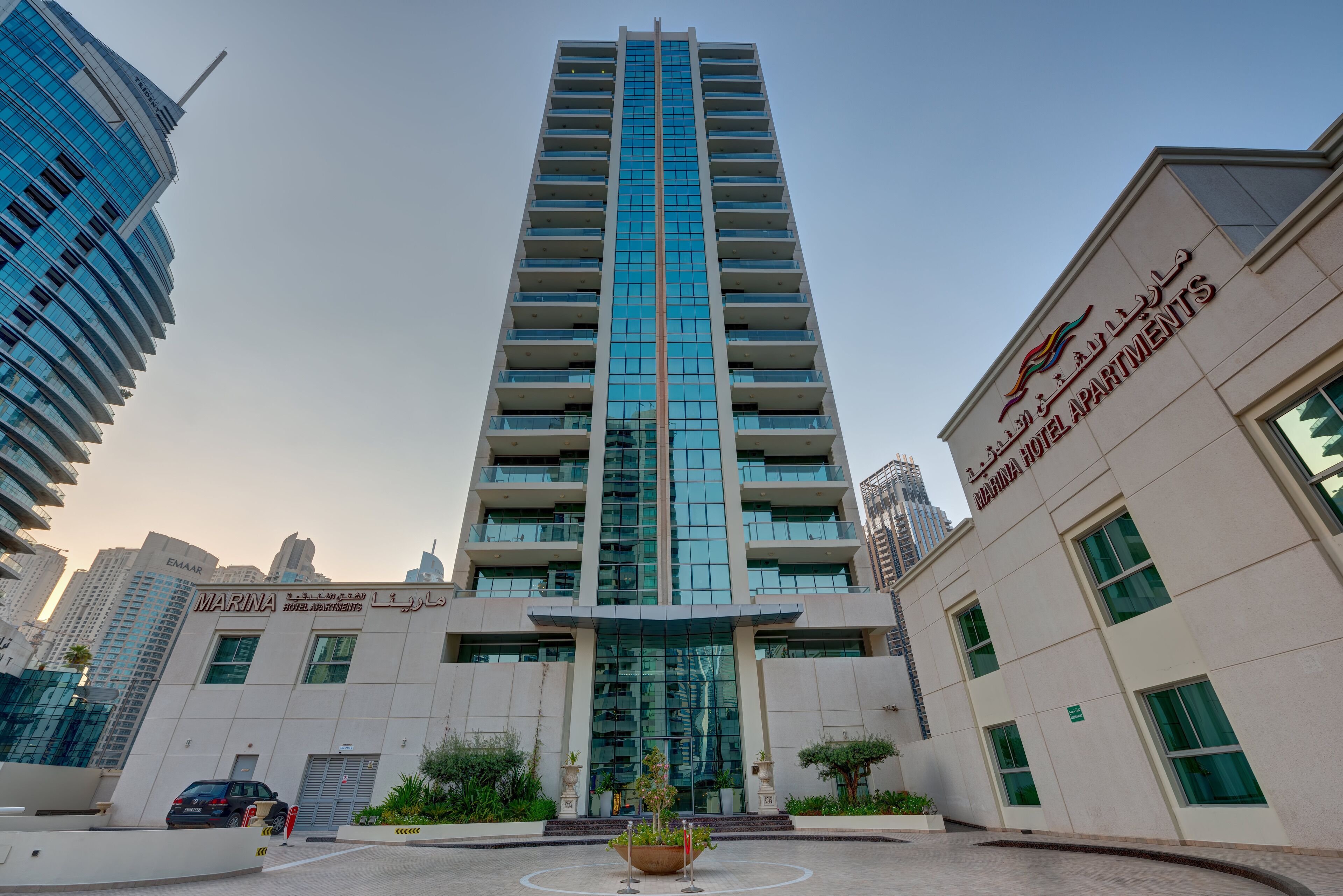 A tall, modern hotel building with a prominent glass facade and a central entrance.