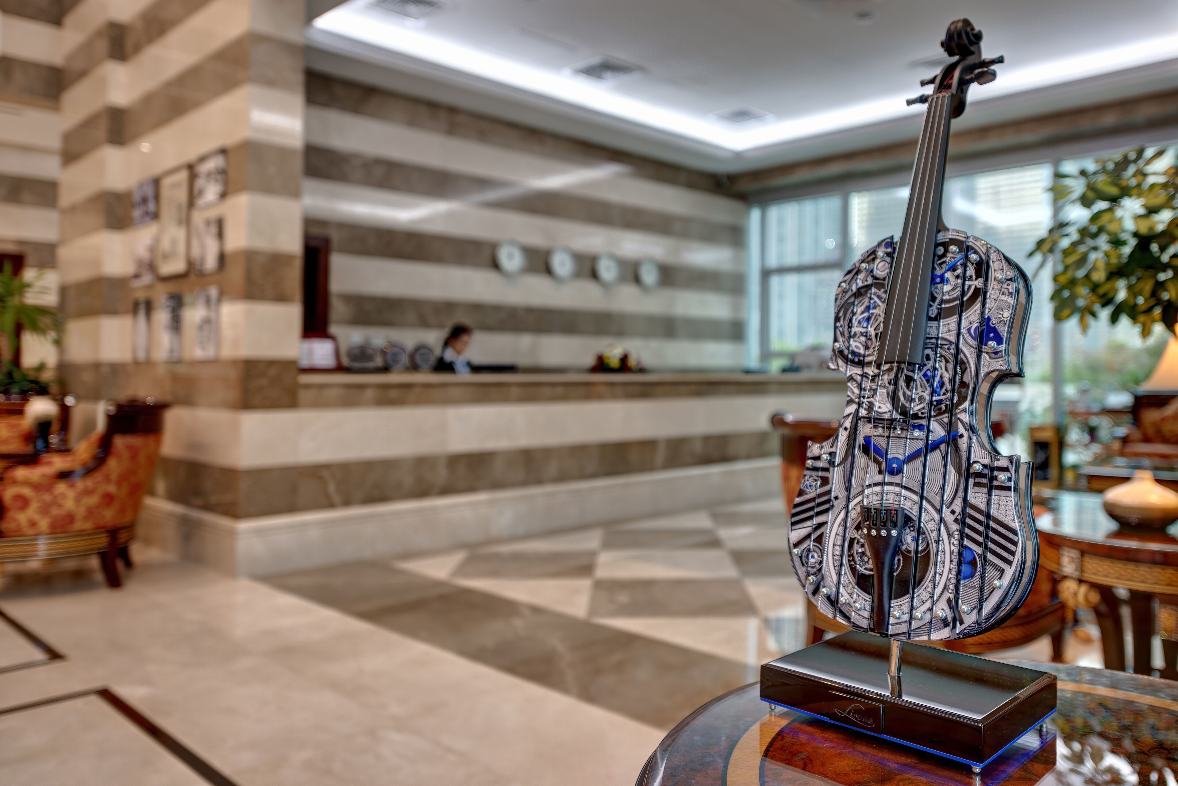 A modern lobby with a checkered floor, a reception desk, and a decorative guitar on display.