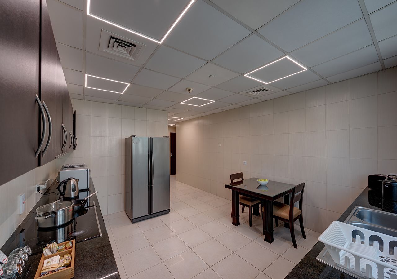 A modern kitchen with a refrigerator, stove, and dining table.