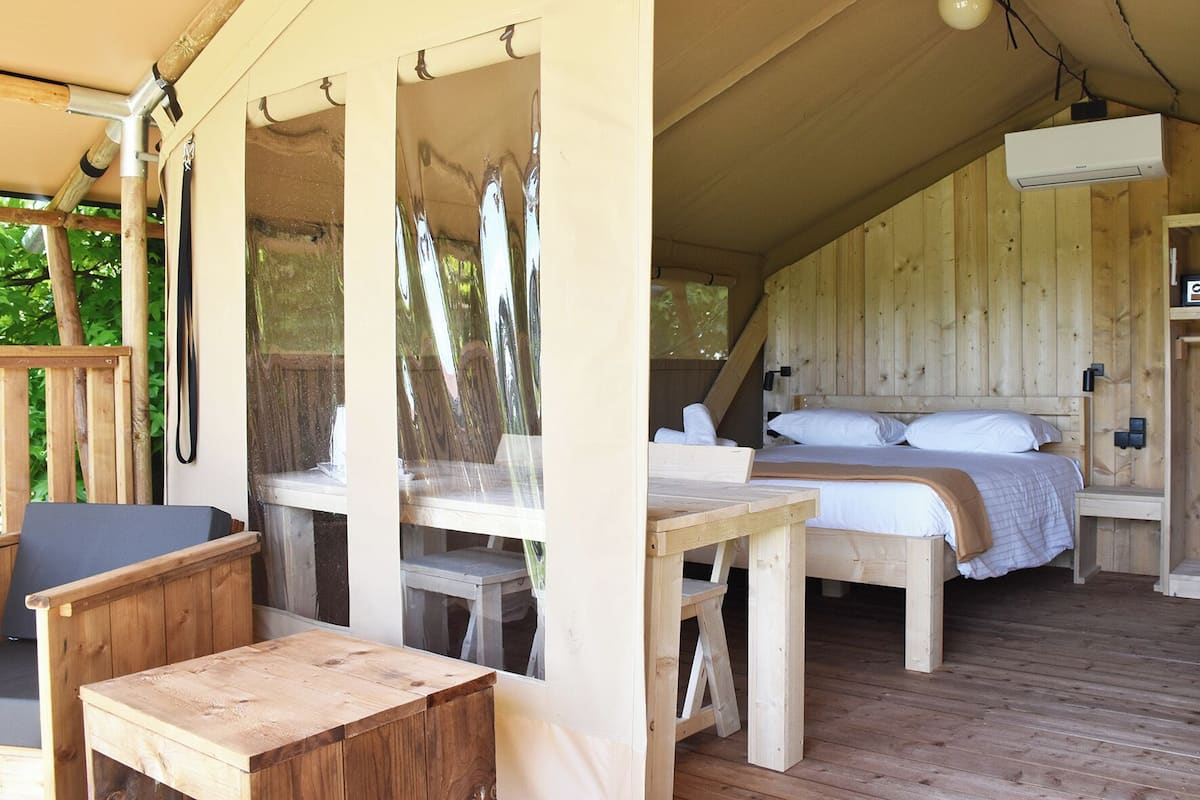 Une cabane en bois avec un lit, une table et une chaise.